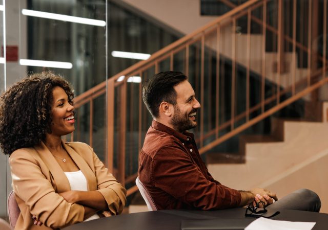 Businesswoman talking to her business clients, in the meeting room.